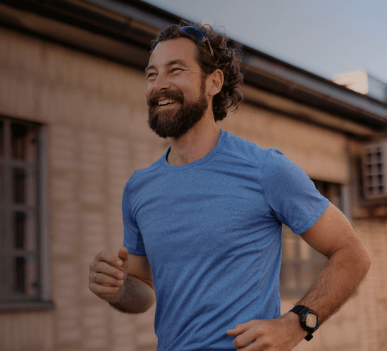 Man smiling while running outdoors